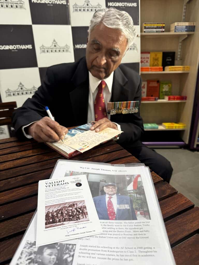 Wing Commander Joseph Thomas signing an envelope