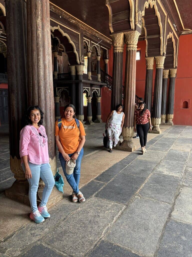 a group of girls standing next to pillars